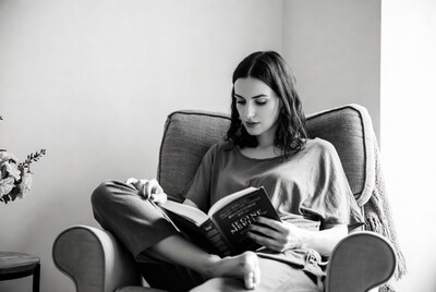 Woman reading book in armchair