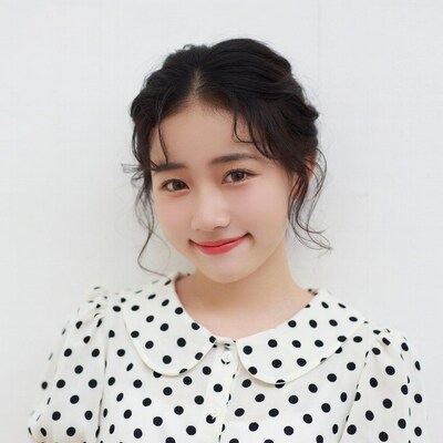 Asian woman in polka dot blouse smiling