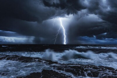 Lightning striking over stormy ocean