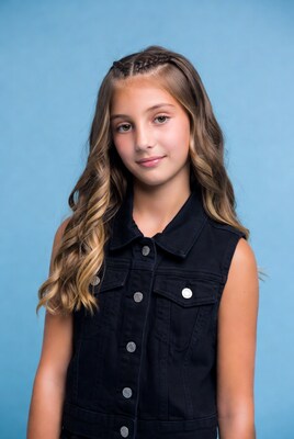 Girl in black denim vest smiling