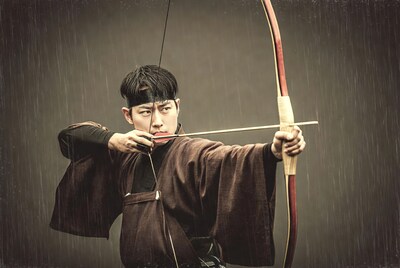 Asian man shooting Japanese bow