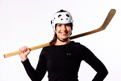 Woman holding hockey stick and helmet