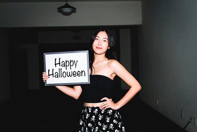 Asian woman holding Happy Halloween sign