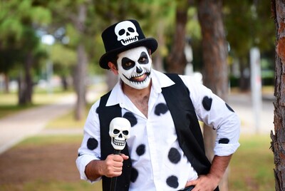 Man in skeleton costume with skull cane