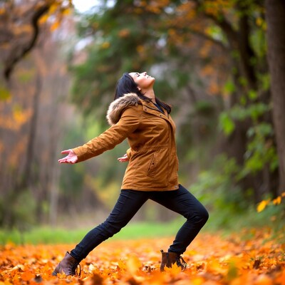 Asian woman arms outstretched autumn forest