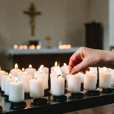 Woman lighting candle in church