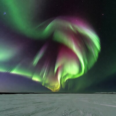 Vibrant Aurora Borealis over Snowy Landscape