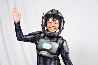 Asian boy waving in astronaut costume