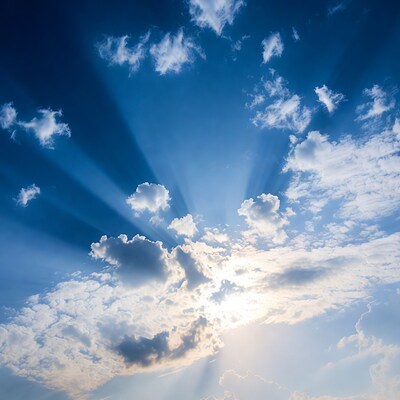 Sun rays through blue sky clouds