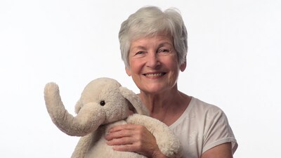 Elderly woman holding teddy elephant