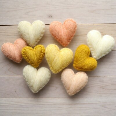 Colorful wool felt hearts on wood