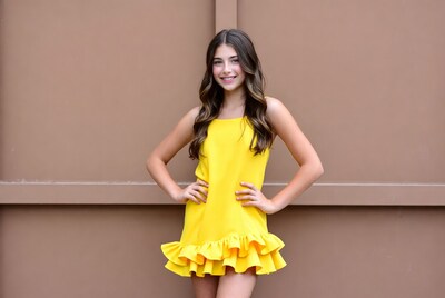 Girl in yellow ruffle dress smiling