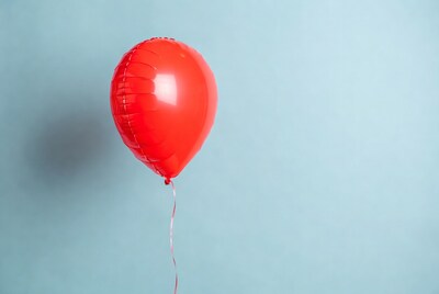 Red foil balloon on blue background