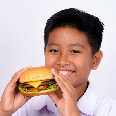 Asian boy holding burger