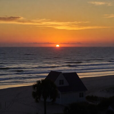 Beach house at sunset with ocean