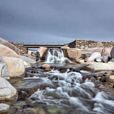 Waterfall over stone bridge rocks