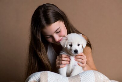 Girl holding white puppy