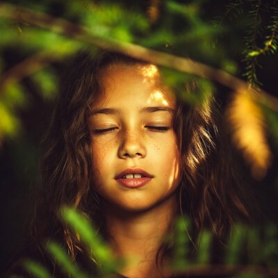 Girl with freckles in green foliage
