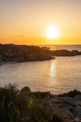 Sunset over rocky coastline beach
