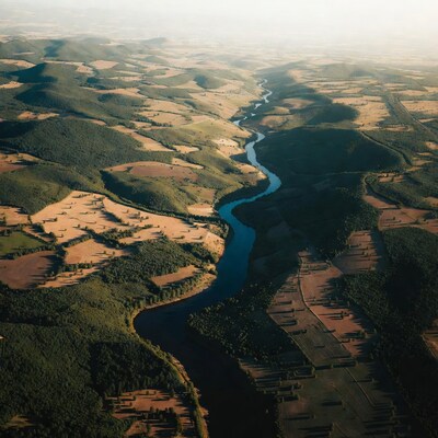 Aerial view of river winding through hills and fields