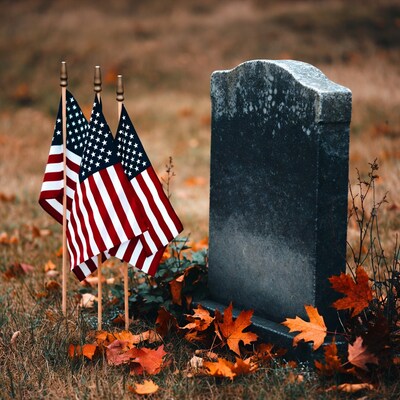 American Flags by Gravestone in Autumn