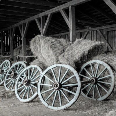 Old wagon wheels and hay bales in barn