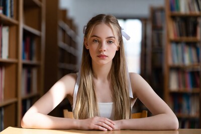 Teen girl with hair ribbon in library