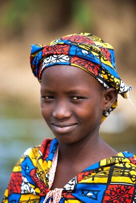African girl in colorful headwrap smiling