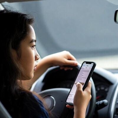 Asian girl texting while driving