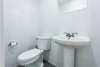 White tiled bathroom with toilet sink