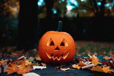 Jack-o-lantern pumpkin with fall leaves