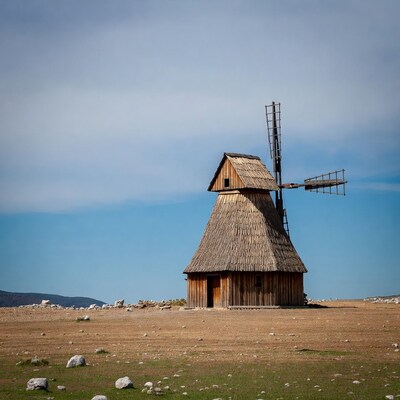 Traditional wooden windmill on rocky plain