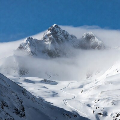 Snowy Mountains with Clouds and Ski Tracks