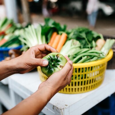 Hands holding green pepper at market