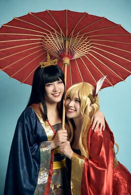 Two women in kimono holding red umbrella