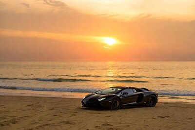 Black Lamborghini Aventador on beach sunset