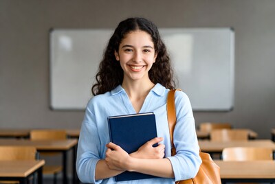 Smiling woman holding book in classroom