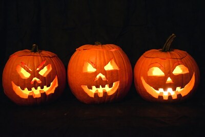 Three lit jack-o-lanterns on black background
