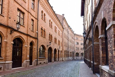 Narrow cobblestone alley between brick buildings