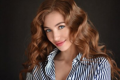 Woman with red wavy hair in striped shirt