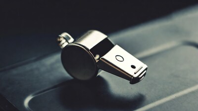 Silver whistle on dark surface