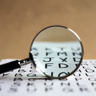 Magnifying glass over alphabet letters