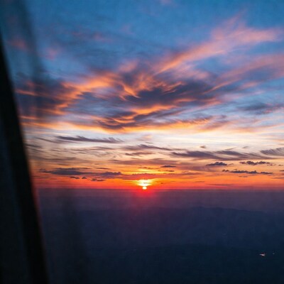 Sunset over mountains through airplane window