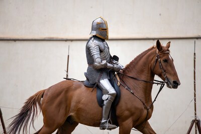 Knight in silver armor riding brown horse