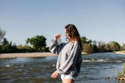 Woman in gray hoodie by river