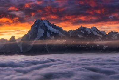 Snowy Mountains Above Clouds at Sunset