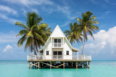 White house on stilts in turquoise ocean