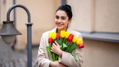 Woman holding tulips by street lamp