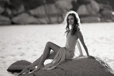 Woman sitting on rock by sea