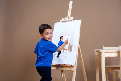 Boy painting self-portrait on easel